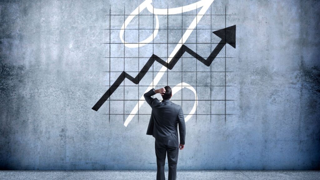 Man standing in front of an interest rate sign and an arrow pointing up